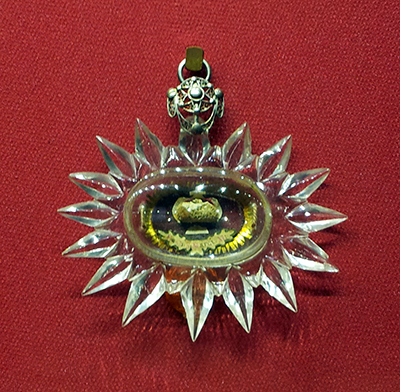 Medallion reliquary (XVII c.) embossed and chased silver filigree; cut glass; silk.