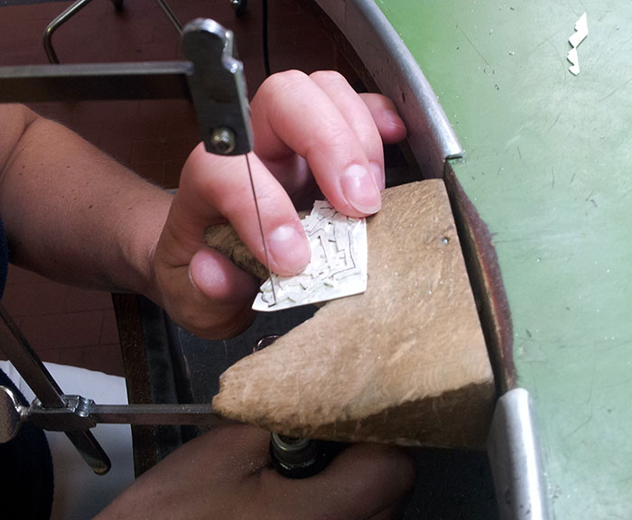 Hand-sawing the silver sheet